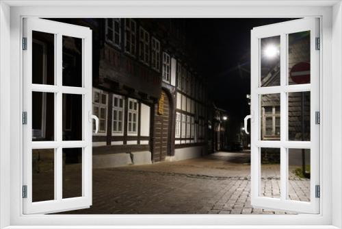 Fototapeta Naklejka Na Ścianę Okno 3D -  Tiny street with old nordic style houses at night in the town of Goslar, Germany in the Harz region.