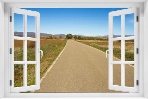 Fototapeta Naklejka Na Ścianę Okno 3D - Secondary road in landscape of agricultural land in autumn with hills and mountains in the background 