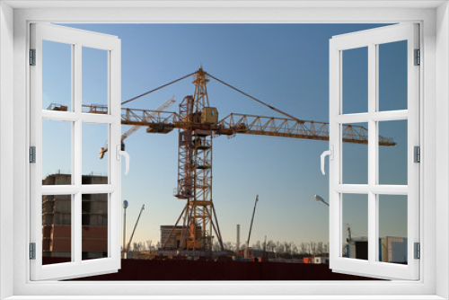 Fototapeta Naklejka Na Ścianę Okno 3D - Tower cranes are working on the construction of a new house. Lifting crane.