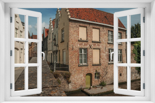 Fototapeta Naklejka Na Ścianę Okno 3D - Bridge and brick buildings on the canal's edge in a sunny day at Bruges. With many canals and old buildings, this graceful town is a World Heritage Site of Unesco. Northwestern Belgium.