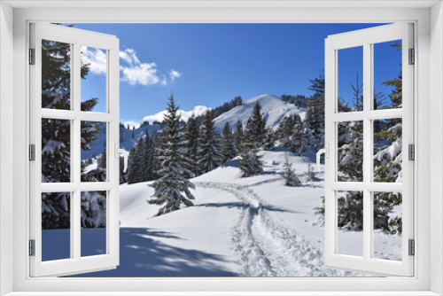 Fototapeta Naklejka Na Ścianę Okno 3D - Snowy landscape in the mountains with forest and ski tracks in winter. Allgäu Alps, Bavaria, Germany