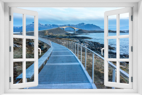 Fototapeta Naklejka Na Ścianę Okno 3D - View of the Storseisundet Bridge with mountains in the background from the elevated path at Eldhusøya on the Atlantic Road in Norway