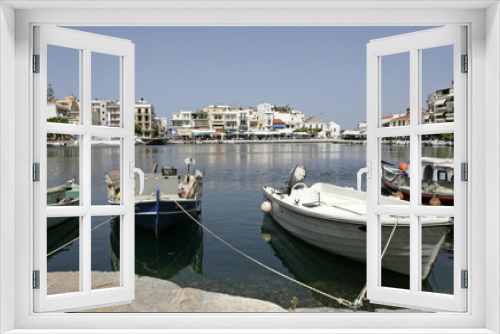 Fototapeta Naklejka Na Ścianę Okno 3D - The white boats on the coast of the lake and white houses and cafes in the small mediterranean town on the sunny day