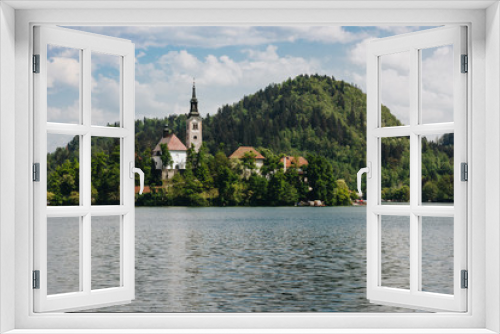 Fototapeta Naklejka Na Ścianę Okno 3D - majestic view of mountains covered with green trees, calm lake and old buildings, bled, slovenia