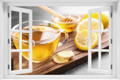 Fototapeta Naklejka Na Ścianę Okno 3D - Cup of delicious tea with lemon and ginger on wooden board