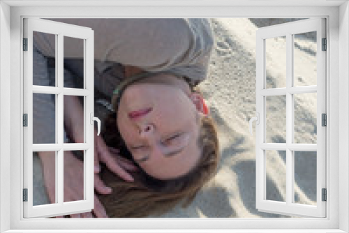 Fototapeta Naklejka Na Ścianę Okno 3D - Woman lies on the sand with her eyes closed