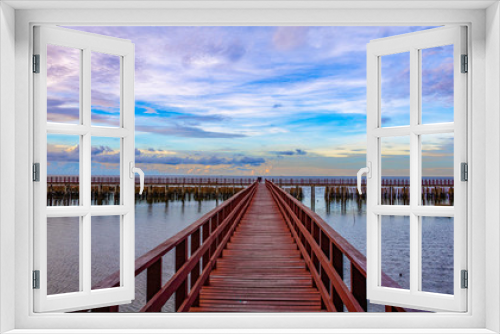 Fototapeta Naklejka Na Ścianę Okno 3D - In the morning The red bridge and sun up or sun set  on horizon.  bridge cross sea in to the forest Thailand .Photo concept for Thailand landscape .