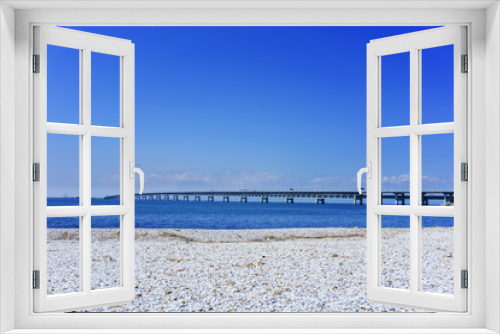 Fototapeta Naklejka Na Ścianę Okno 3D - Beautiful artificial marble beach along the shoreline of Rinku Town , viewing Kansai kokusai kuko renraku-kyo ( toll road ) across blue sea of Osaka bay to Kansai International airport , Osaka , Japan