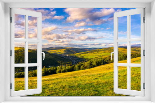 Fototapeta Naklejka Na Ścianę Okno 3D - beautiful Carpathian countryside at sunset. village down in the valley in shade of a nearby mountain. beautiful colorful sky with clouds. Great water dividing ridge in the far distance