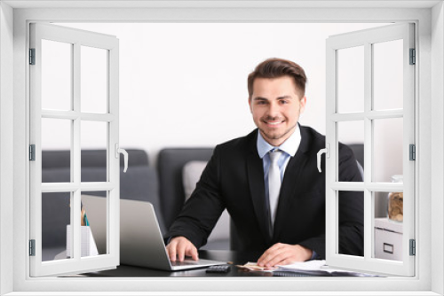 Young businessman counting money at table indoors. Money savings concept