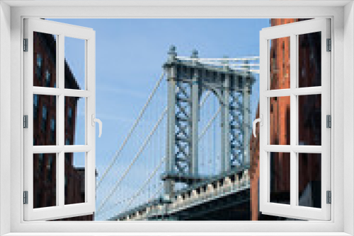 Fototapeta Naklejka Na Ścianę Okno 3D - A view of Manhattan Bridge from between two buildings in Brooklyn
