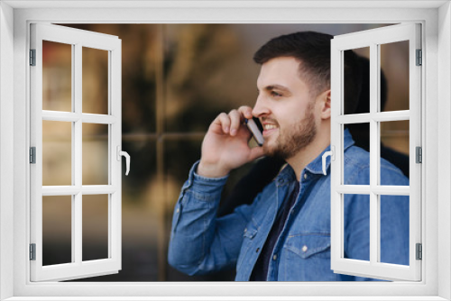 Hamdsome beard man taking a call on his phone