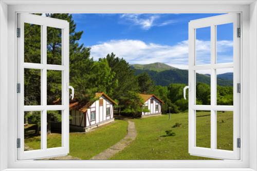 Fototapeta Naklejka Na Ścianę Okno 3D - Beautiful cottages in the background of the mountains on a summer day