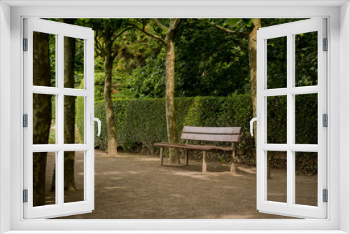 Fototapeta Naklejka Na Ścianę Okno 3D - bench in park surrounded by trees and a hedge