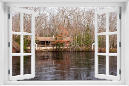 Fototapeta Naklejka Na Ścianę Okno 3D - Cabin by a Freezing Lake  in the Woods
