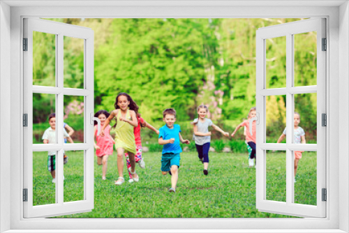 Many different kids, boys and girls running in the park on sunny summer day in casual clothes