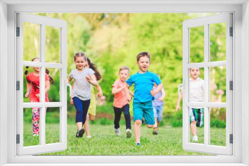 Many different kids, boys and girls running in the park on sunny summer day in casual clothes