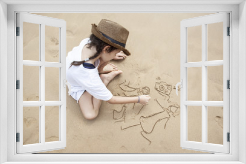 Fototapeta Naklejka Na Ścianę Okno 3D - The girl the child draws in the sand