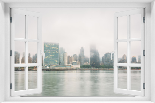 Fototapeta Naklejka Na Ścianę Okno 3D - Foggy view of the Manhattan skyline from Gantry Plaza State Park, in Long Island City, Queens, New York City.