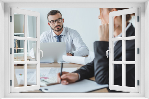 financiers looking at each other at table in office