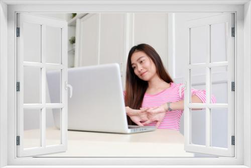 Young asian woman stretching body for relaxing while working with laptop computer at home office, working from home