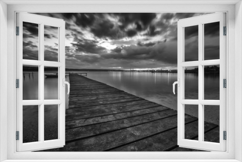 Fototapeta Naklejka Na Ścianę Okno 3D - Black and white landscape with wooden pier and fishing boat at the lake after sunset