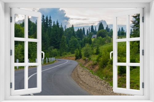 Fototapeta Naklejka Na Ścianę Okno 3D - The road against the background of green mountains with a huge number of different vegetation and small rural houses