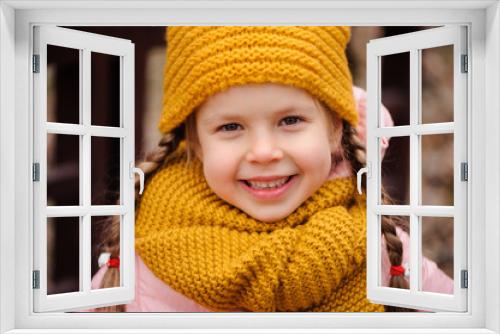 autumn close up portrait of happy little child girl enjoying the walk in sunny park in warm knitted hat and scarf