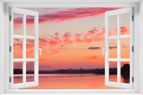 dramatic sunset with red sky and clouds, reflections on still water, warm summer countryside dusk panorama background photo