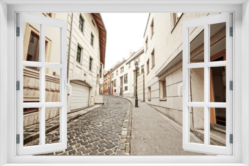 Fototapeta Naklejka Na Ścianę Okno 3D - Empty narrow cobblestone street in old town