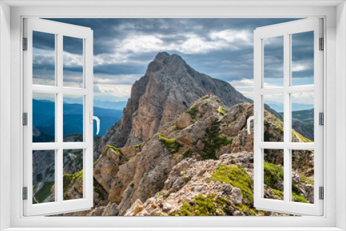 Fototapeta Naklejka Na Ścianę Okno 3D - Hiker on the ridge of Dolomites Mountains in Alps, Italy. Via ferrata trail. Peole on the rocky mountains path. Travel in Dolomites. Adventure in the mountains. Mountain climber on an exposed ledge