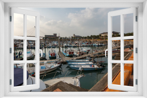 Fototapeta Naklejka Na Ścianę Okno 3D - View from Fisherman's Wharf located along the coast of Tamsui District, New Taipei City Taiwan. Harbor with boats and sunset with calm water, ocean boats and buildings in the background.