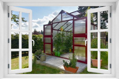 Fototapeta Naklejka Na Ścianę Okno 3D - Ein rotes Gewächshaus im Garten