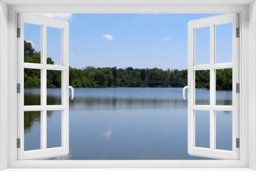 Fototapeta Naklejka Na Ścianę Okno 3D - The reflections of the trees and the clouds off the lake. 