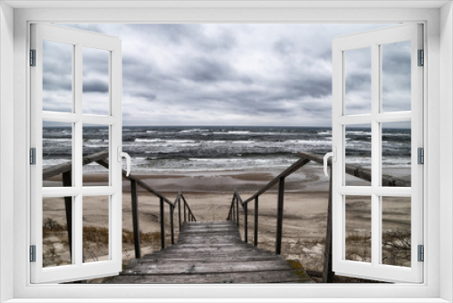 Fototapeta Naklejka Na Ścianę Okno 3D - Wooden staircase among the sand on a cloudy day