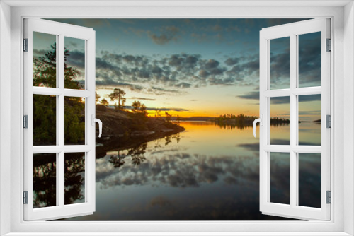 Fototapeta Naklejka Na Ścianę Okno 3D - Dawn over the lake. The clouds are reflected in the water. Islands in the rays of dawn. Wild nature. Karelia. Russia. Nature of Russia.