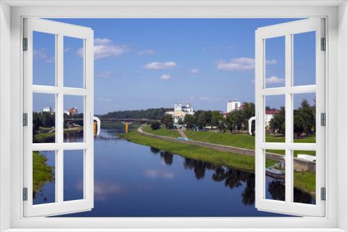 Fototapeta Naklejka Na Ścianę Okno 3D - Urban landscape. The blue sky is reflected in the river.