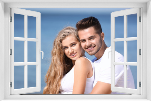 Happy young couple at beach on sunny day