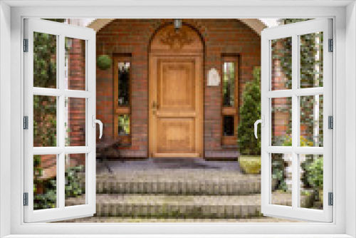 Fototapeta Naklejka Na Ścianę Okno 3D - Elegant, wooden entrance door to an estate with ivy growing on brick walls