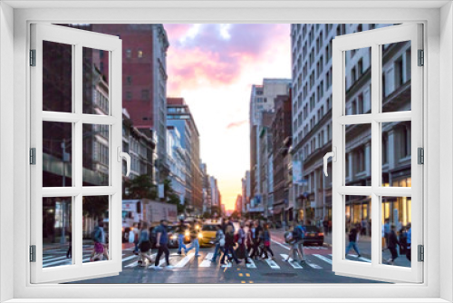 Fototapeta Naklejka Na Ścianę Okno 3D - Diverse group of people walking across the busy intersection 23rd Street and 6th Avenue in Manhattan with the colorful light of sunset shining through the skyline buildings