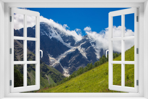 Fototapeta Naklejka Na Ścianę Okno 3D - Summer mountain landscape of the North Caucasus. Snow-capped peaks and green grass in the foreground.