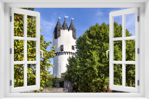 Fototapeta Naklejka Na Ścianę Okno 3D - Germany, Rhine-Main area, Hanau, Steinheim: Famous white donjon tower in the green castle park of the German town with flags, old vintage city wall, trees and blue sky - concept travel architecture