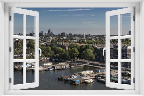 Fototapeta Naklejka Na Ścianę Okno 3D - View north, over Amsterdam city, with many boats alongside the large canal. It is summertime and the sky is blue