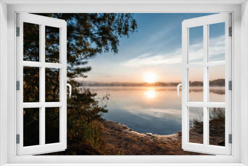 Fototapeta Naklejka Na Ścianę Okno 3D - Beautiful, red dawn on the lake. The rays of the sun through the fog. The blue sky over the lake, the morning comes, the sky is reflected in the water.