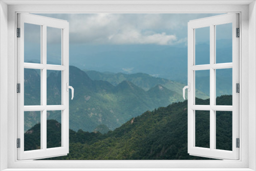 forest covered mountain range under partially cloudy sky