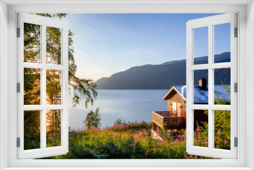 Fototapeta Naklejka Na Ścianę Okno 3D - Wooden summerhouse with terrace overlooking scenic lake at sunset in Norway Scandinavia