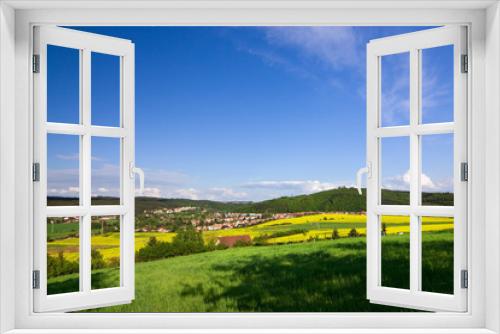 Fototapeta Naklejka Na Ścianę Okno 3D - Spring landscape with a field of yellow rape and blue sky