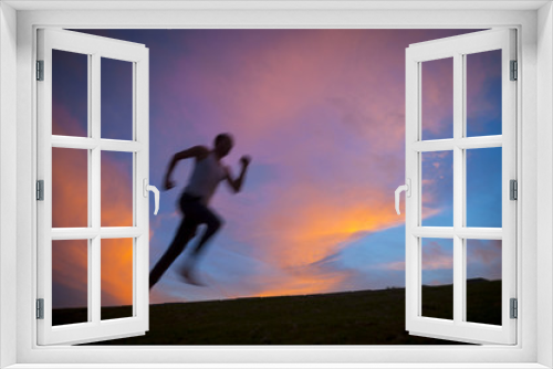 Fototapeta Naklejka Na Ścianę Okno 3D - Motion blur silhouette of man running against vibrant sunrise sky