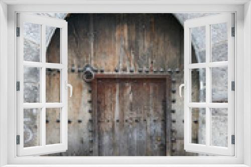 Ancient dark wood entrance door of a stone house