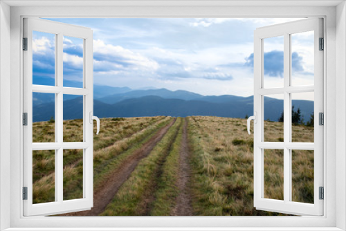 Fototapeta Naklejka Na Ścianę Okno 3D - road to nowhere on the top of the hill in the mountains, blue sky